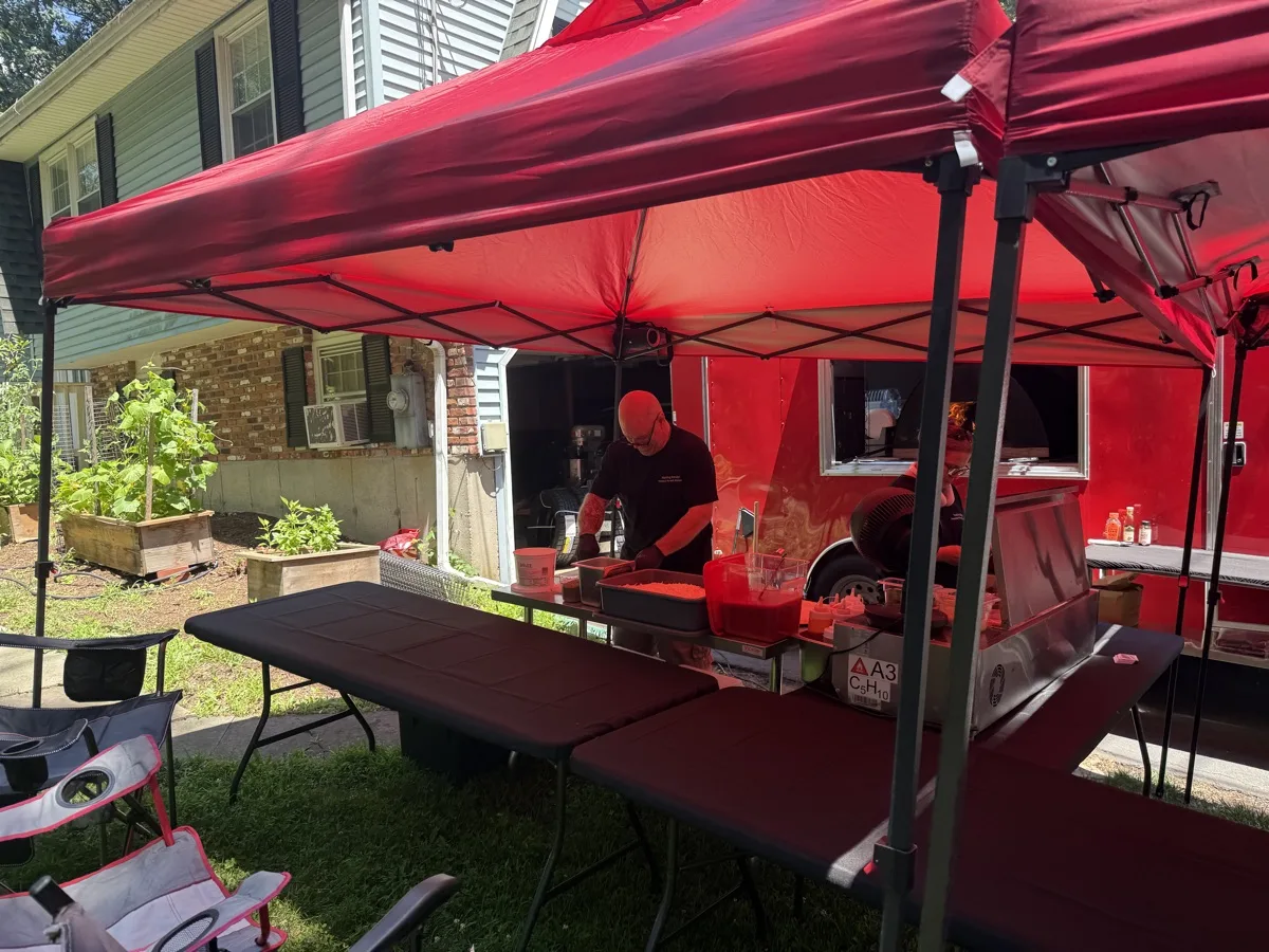 Rollin Dough pizza trailer set up under red tents for a backyard pizza party in Guilford CT