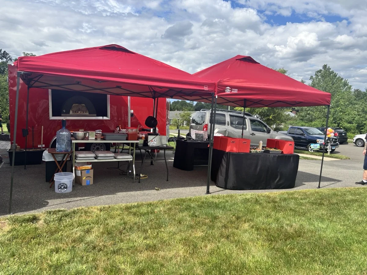 Rollin Dough mobile pizza trailer catering setup with canopy tents at a Connecticut event