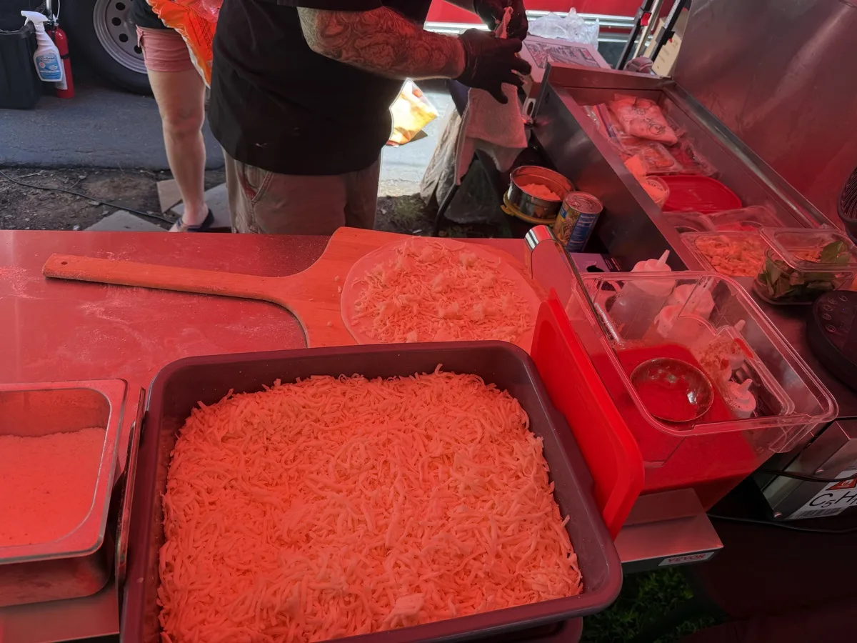 Fresh shredded mozzarella and toppings on the prep line at a Connecticut wood fired pizza catering event