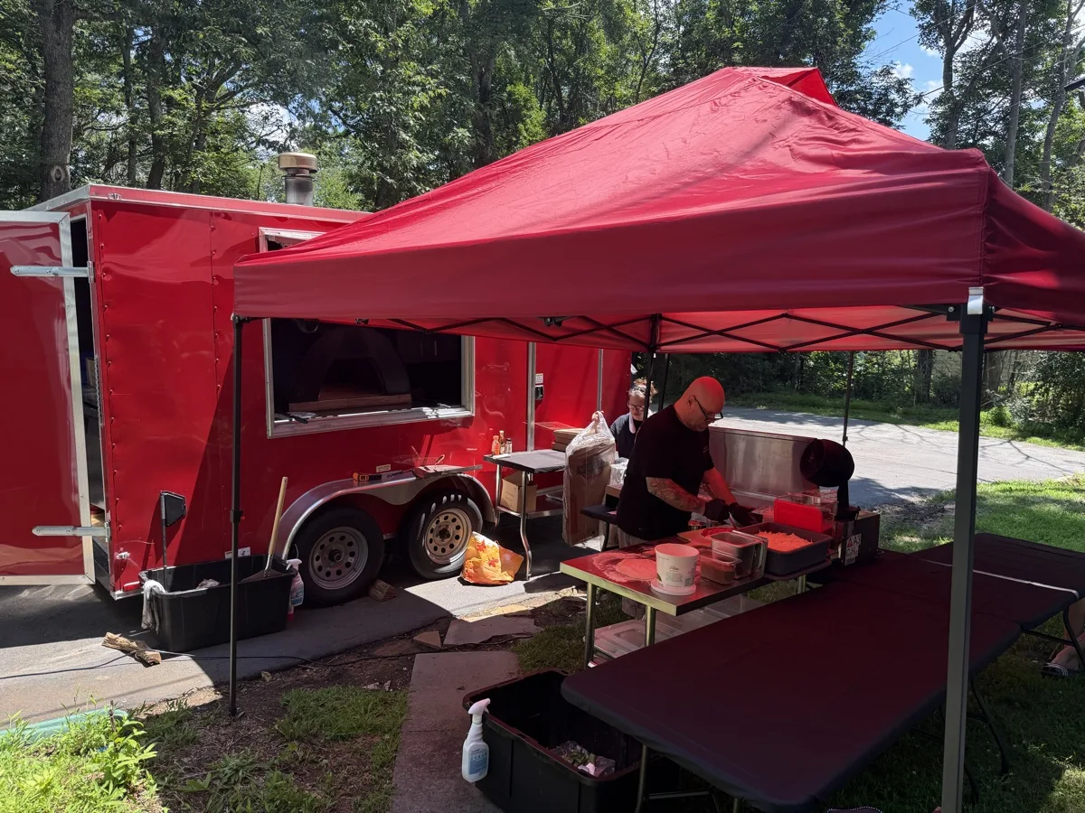Rollin Dough wood fired apizza trailer and catering tent set up for an outdoor event in Connecticut