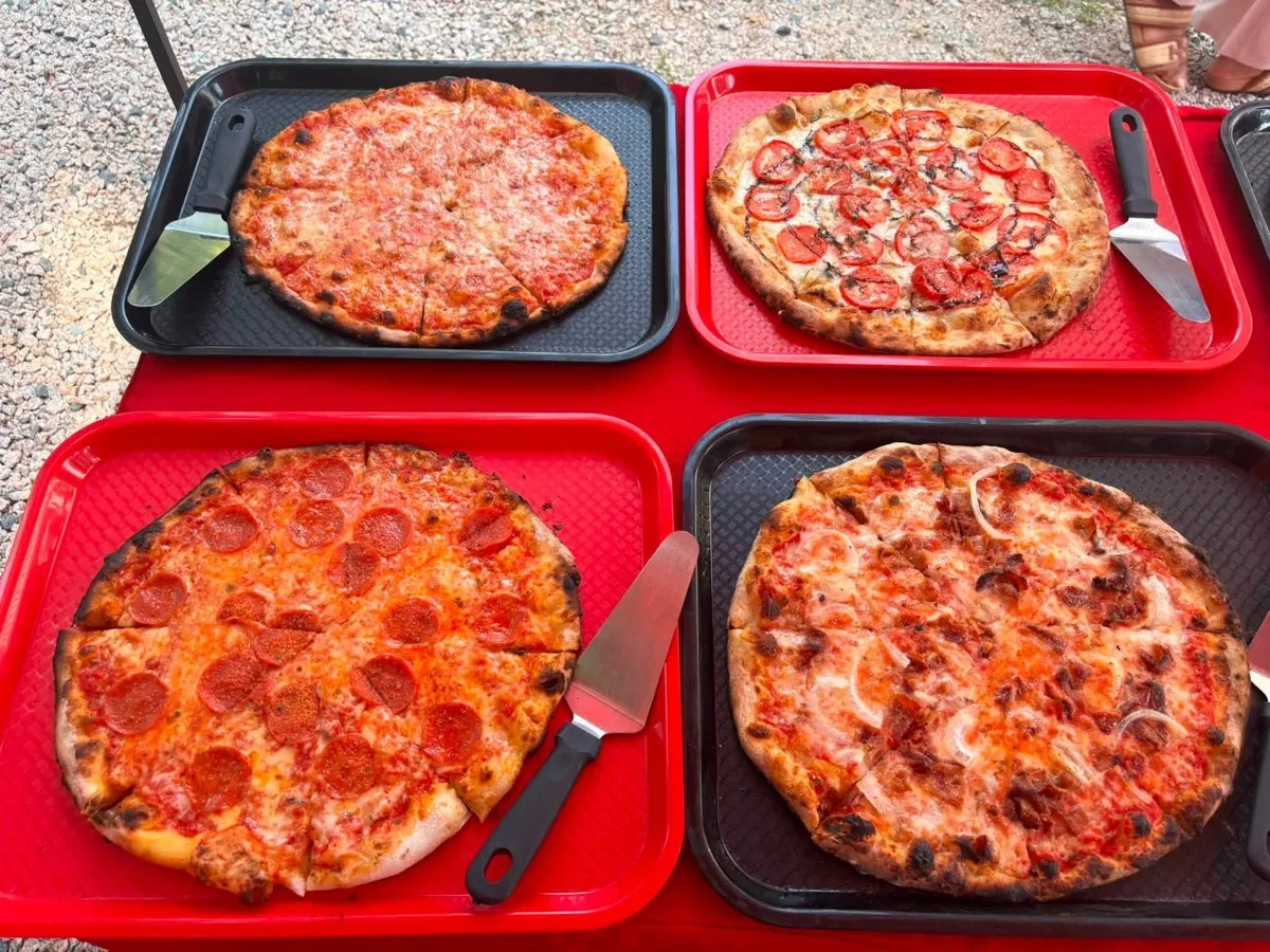 Cheese, fresh tomato, pepperoni and sausage wood fired apizzas ready to serve at a Connecticut catering event
