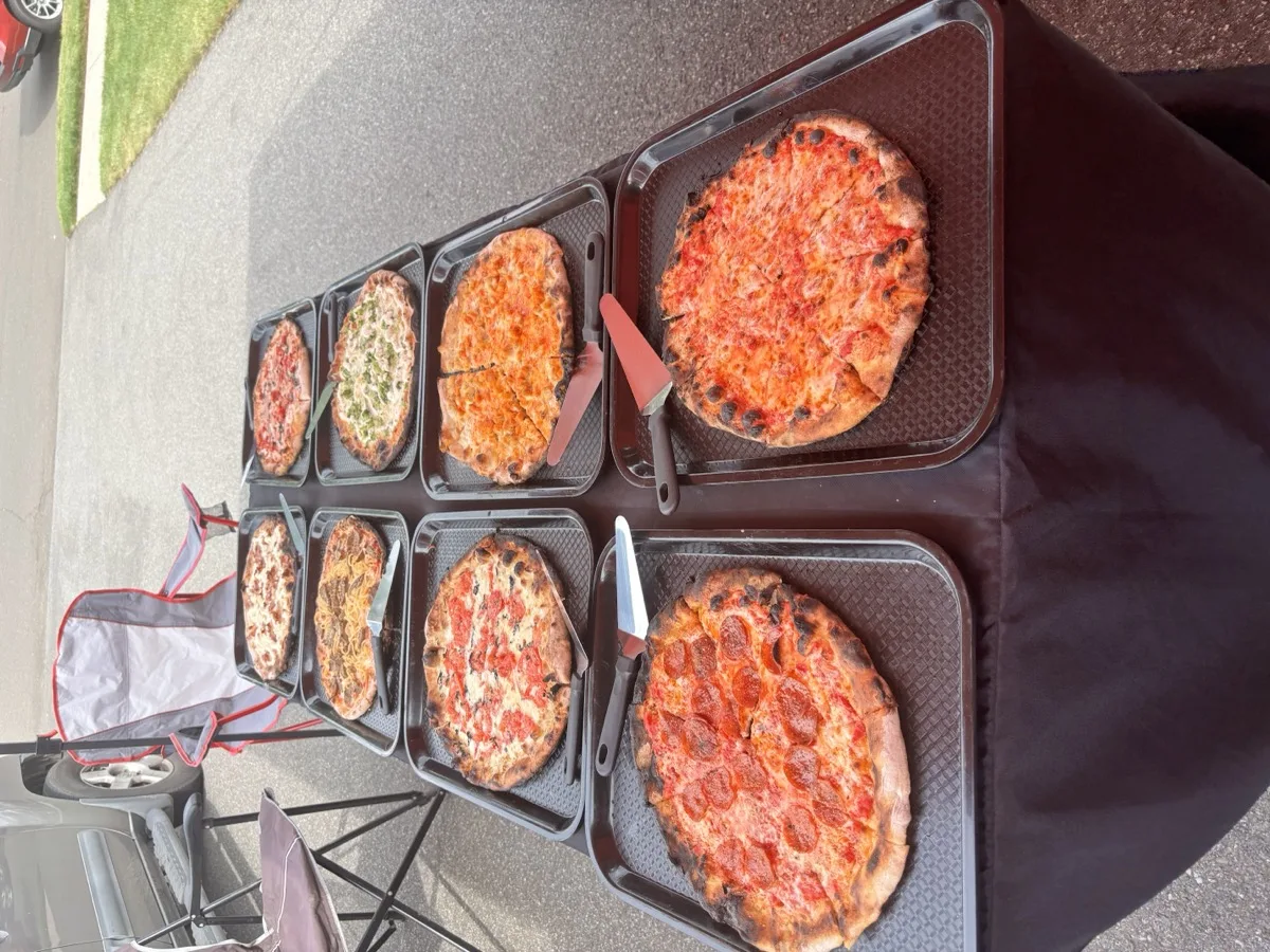 Spread of wood fired apizzas at a Rollin Dough pizza party catering event in Guilford CT